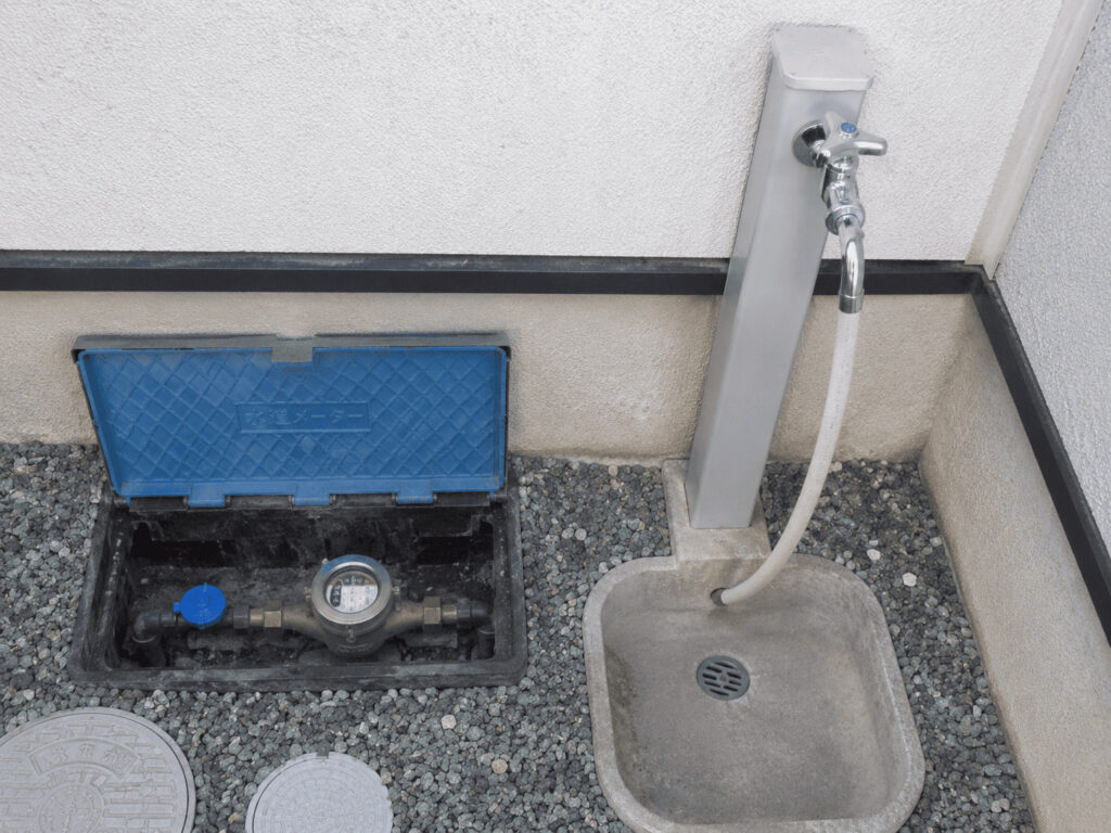 戸建て住宅の屋外に設置されている水道メーターと止水栓