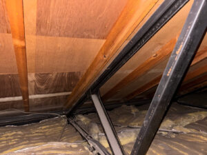 屋根裏の鉄骨トラスとグラスウール断熱材
